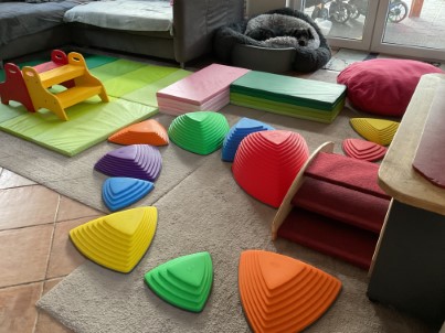Weiche, bunte Bewegungsmaterialien liegen im Spielraum bereit.